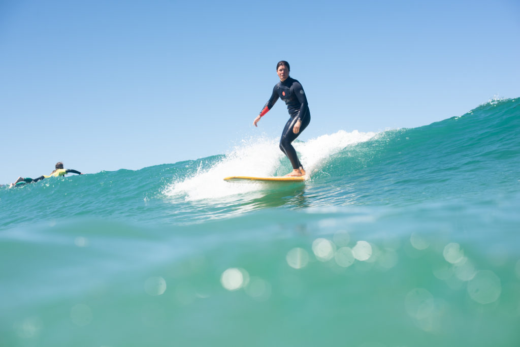 A Surfer longboarding a wave in sunny Newquay