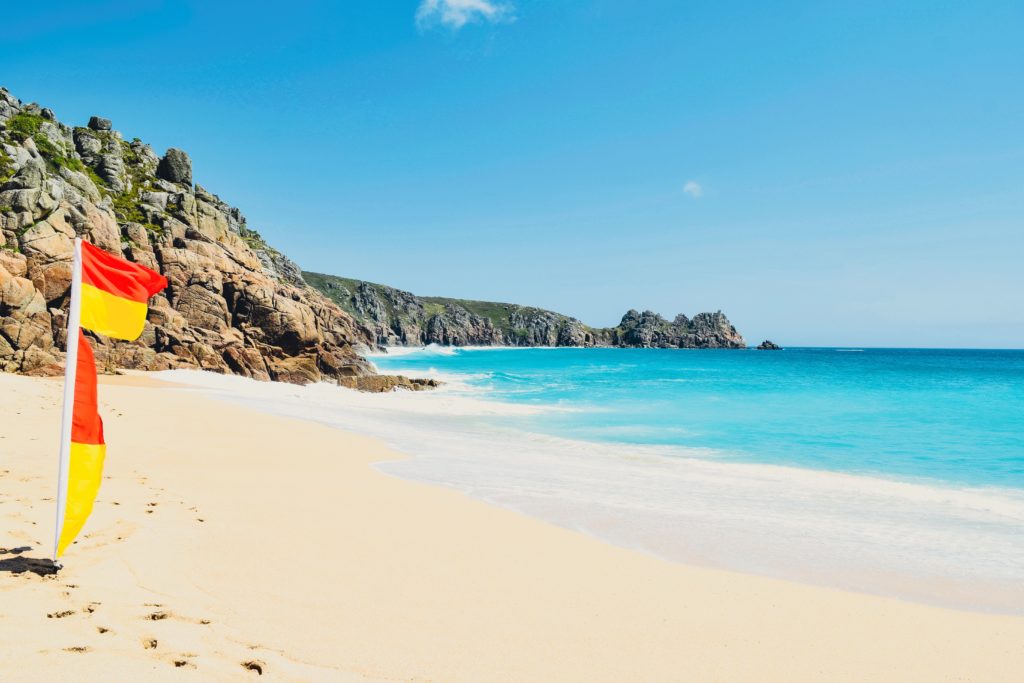 Lifeguarded beach Porthcurno with the red and yellow swimming flags up. 