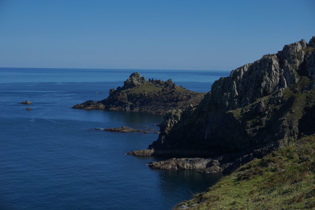 A view of Gurnards Heads. Clear blue sea and a rocky outcrop headland spitting out into the sea