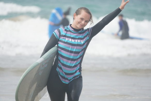 tab smiling as she walks up the beach.
