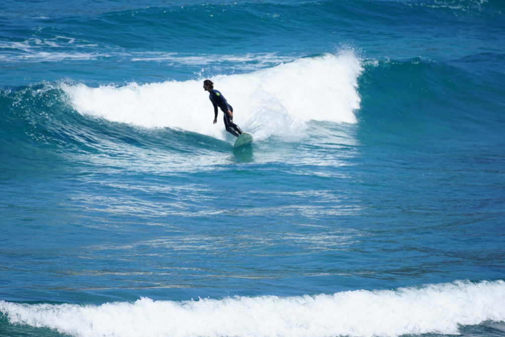 A local surfer drops in on a right hand wave at a beach in Menorca